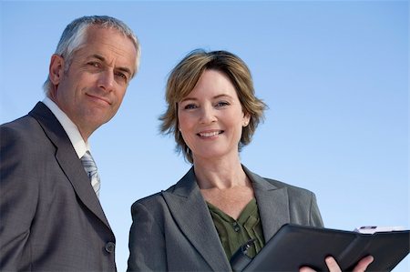 A business man and woman looking confident with the sky as the background Stock Photo - Budget Royalty-Free & Subscription, Code: 400-04562420