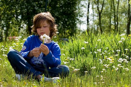 young boy is sitting in the grass Stock Photo - Budget Royalty-Free & Subscription, Code: 400-04563010