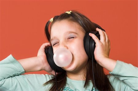 Young girl enjoying the music and making a bubble from chewing gum Stock Photo - Budget Royalty-Free & Subscription, Code: 400-04563885