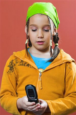 Young girl with green kerchief looking a typing on a mobile phone Stock Photo - Budget Royalty-Free & Subscription, Code: 400-04563883