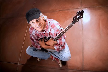 simsearch:400-05080507,k - Banjo Player Sitting Indoors on Cement Floor Stock Photo - Budget Royalty-Free & Subscription, Code: 400-04574183