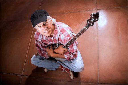 Banjo Player Sitting Indoors on Cement Floor Photographie de stock - Aubaine LD & Abonnement, Code: 400-04574183