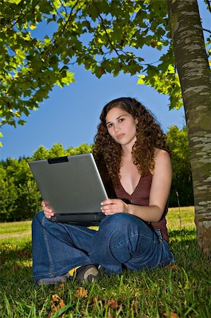 simsearch:6109-06003537,k - A beautiful young girl, using her laptop on a park. Fotografie stock - Microstock e Abbonamento, Codice: 400-04574351