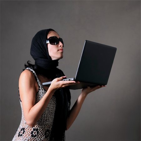 peeping fashion - Portrait of classy woman with sunglasses holding laptop Stock Photo - Budget Royalty-Free & Subscription, Code: 400-04574550