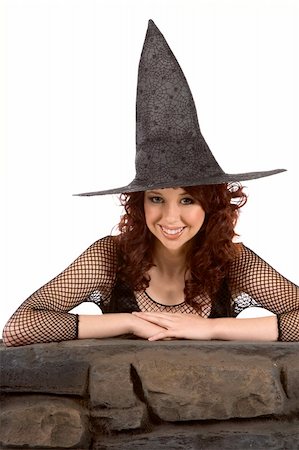 simsearch:400-04007612,k - Portrait of Hispanic teenager girl in black Halloween hat and fishnet dress by stone fence Stock Photo - Budget Royalty-Free & Subscription, Code: 400-04574706