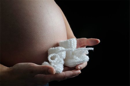 Pregnant mother holding a pair of baby shoes Fotografie stock - Microstock e Abbonamento, Codice: 400-04575568