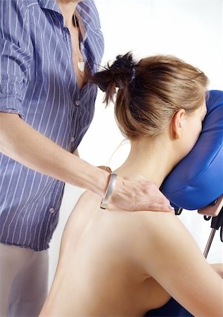 Woman gets massage on her shoulder from physiotherapist, sitting on massage seat Fotografie stock - Microstock e Abbonamento, Codice: 400-04576271