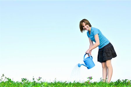Smiling teenage girl with watering can on green grass Stock Photo - Budget Royalty-Free & Subscription, Code: 400-04576381