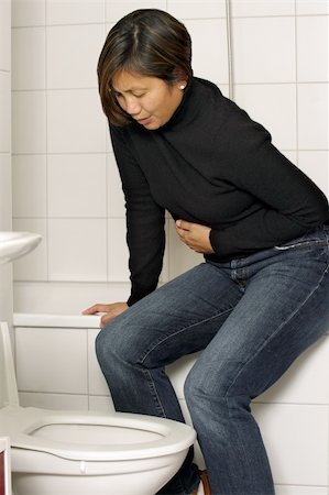 Asian woman with stomach sickness about to vomit into her toilet. Stock Photo - Budget Royalty-Free & Subscription, Code: 400-04576734