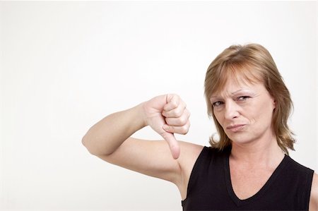 pursed - Mature adult female frowning while giving a thumb down signal Stock Photo - Budget Royalty-Free & Subscription, Code: 400-04576854