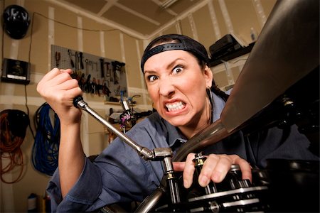 Funny female Hispanic mechanic  working on a chopper style motorcycle Stock Photo - Budget Royalty-Free & Subscription, Code: 400-04577016