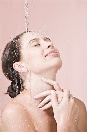 simsearch:400-05112444,k - Portrait of young beautiful woman  getting splashed on pink background Stock Photo - Budget Royalty-Free & Subscription, Code: 400-04579103