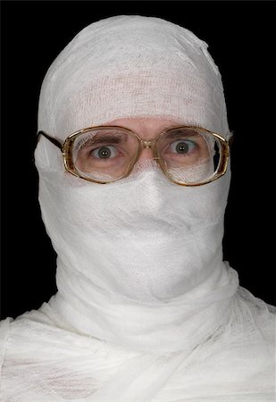 Head of the guy rolled up by bandage in spectacles on a black background Stock Photo - Budget Royalty-Free & Subscription, Code: 400-04579765