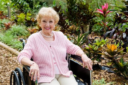 Beautiful disabled senior woman in the garden.   Horizontal view with room for text. Foto de stock - Super Valor sin royalties y Suscripción, Código: 400-04571636