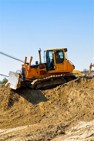 simsearch:400-06171776,k - Yellow bulldozer machines digging and moving earth at construction site Fotografie stock - Microstock e Abbonamento, Codice: 400-04586184