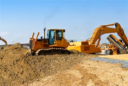 simsearch:400-05326745,k - Yellow bulldozer machines digging and moving earth at construction site Foto de stock - Royalty-Free Super Valor e Assinatura, Número: 400-04586185