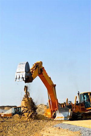 simsearch:400-05326745,k - Yellow bulldozer machines digging and moving earth at construction site Foto de stock - Royalty-Free Super Valor e Assinatura, Número: 400-04586183