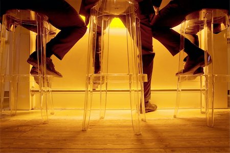 person sitting bar stool - Conceptual image of three socializing business men sitting on barstools in a trendy, bright orange lit bar after a long day of work Stock Photo - Budget Royalty-Free & Subscription, Code: 400-04586457