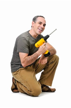 simsearch:400-08054637,k - Kneeling happy handyman with his cordless drill Stock Photo - Budget Royalty-Free & Subscription, Code: 400-04587212