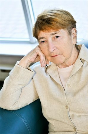Sad elderly woman sitting on a couch indoors Stock Photo - Budget Royalty-Free & Subscription, Code: 400-04587232