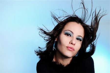 simsearch:400-05092676,k - Portrait of young fashion woman with blowing hair over blue background Stock Photo - Budget Royalty-Free & Subscription, Code: 400-04587444