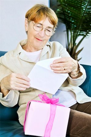 Elderly woman opening birthday card and present Stock Photo - Budget Royalty-Free & Subscription, Code: 400-04587873