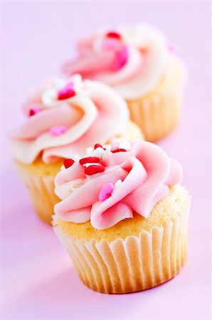 simsearch:400-07549504,k - Row of tasty cupcakes with icing and sprinkles Photographie de stock - Aubaine LD & Abonnement, Code: 400-04588181