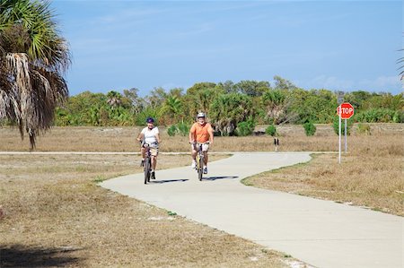 Active senior couple bicycling through the park. Foto de stock - Super Valor sin royalties y Suscripción, Código: 400-04588825