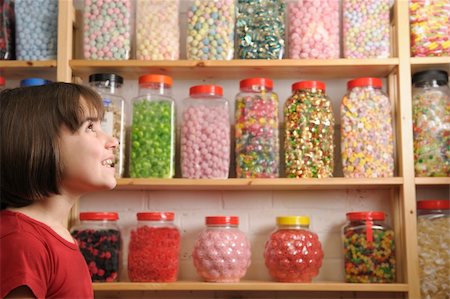 spoiled for choice - young girl smiling at camera in sweet shop Stock Photo - Budget Royalty-Free & Subscription, Code: 400-04589353