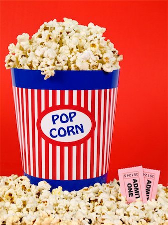 simsearch:400-04913050,k - A popcorn bucket over a red background. Movie stubs sitting over the popcorn. Photographie de stock - Aubaine LD & Abonnement, Code: 400-04589597