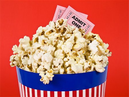 simsearch:400-04913050,k - A popcorn bucket over a red background. Movie stubs sitting over the popcorn. Photographie de stock - Aubaine LD & Abonnement, Code: 400-04589598