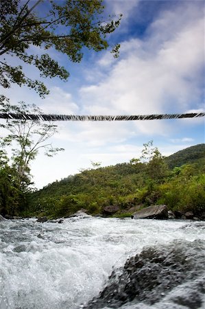 simsearch:400-04833071,k - A hanging bridge over a rapid flowing stream Photographie de stock - Aubaine LD & Abonnement, Code: 400-04581406