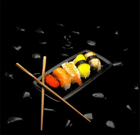 simsearch:400-04397537,k - assorted sushi plate on black pebbles over black background Stockbilder - Microstock & Abonnement, Bildnummer: 400-04594635