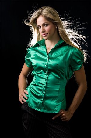Beautiful young woman with blond hair wearing shiny green satin blouse posing on black background Stock Photo - Budget Royalty-Free & Subscription, Code: 400-04596342