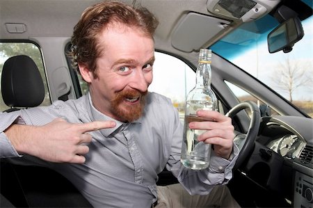 simsearch:400-04947548,k - Man sitting in drivers with a bottle alcohol Stock Photo - Budget Royalty-Free & Subscription, Code: 400-04596789