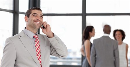 simsearch:400-04113098,k - Potrait of a Businessman on the phone in front of business team Stock Photo - Budget Royalty-Free & Subscription, Code: 400-04598680