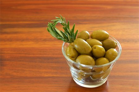 simsearch:400-04598775,k - Single jar of green olives with stick of rosemary on wooden table background with copy space Photographie de stock - Aubaine LD & Abonnement, Code: 400-04598775