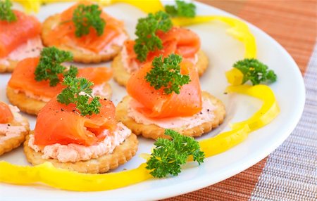 poco appetitoso - Smoked salmon and cream cheese on mini crackers with freshly cracked black pepper and garnishing of parsley Photographie de stock - Aubaine LD & Abonnement, Code: 400-04598884