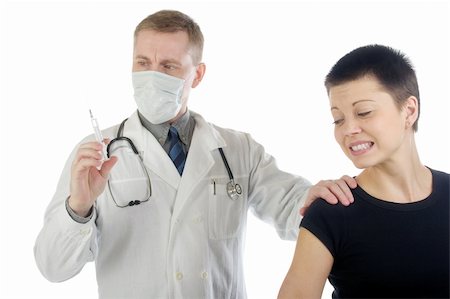 Doctor in gauze mask checks up a syringe while he holds a frightened woman by her shoulder Foto de stock - Super Valor sin royalties y Suscripción, Código: 400-04599821