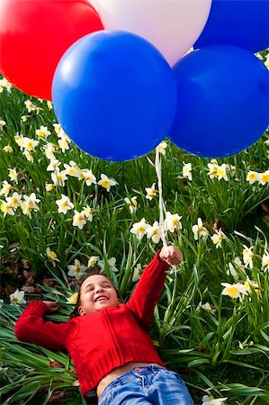 A beautiful young mixed race girl playing with balloons in a field of daffodils Stock Photo - Budget Royalty-Free & Subscription, Code: 400-04590035