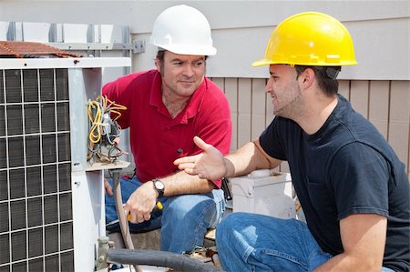 Air conditioning repairmen discussing the problem with a compressor unit. Foto de stock - Super Valor sin royalties y Suscripción, Código: 400-04590669