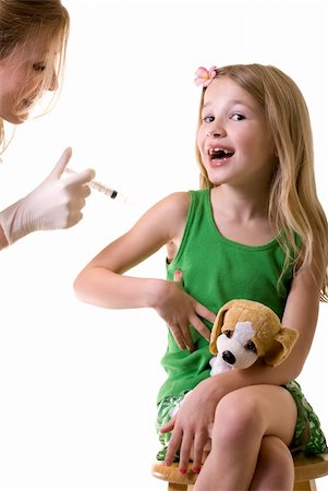Female nurse or doctor holding a syringe with little girl child sitting looking at needle Stock Photo - Budget Royalty-Free & Subscription, Code: 400-04590952