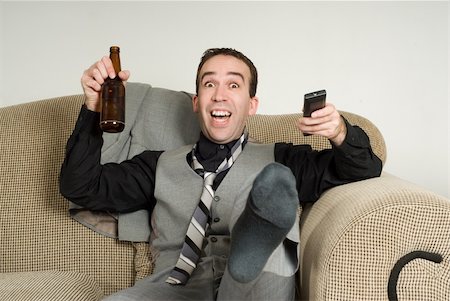 dragon_fang (artist) - An excited businessman kicking and cheering at something he is watching on tv Fotografie stock - Microstock e Abbonamento, Codice: 400-04591795