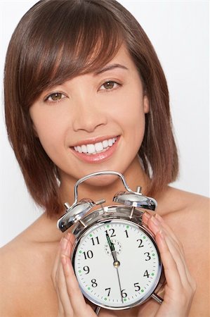 perfect timing - A naturally beautiful oriental woman make up free and holding an alarm clock just about to get to 12 o'clock Stock Photo - Budget Royalty-Free & Subscription, Code: 400-04592957