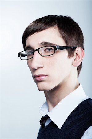 simsearch:400-05912369,k - Cute young guy with fashion haircut wearing glasses on blue Fotografie stock - Microstock e Abbonamento, Codice: 400-04593287