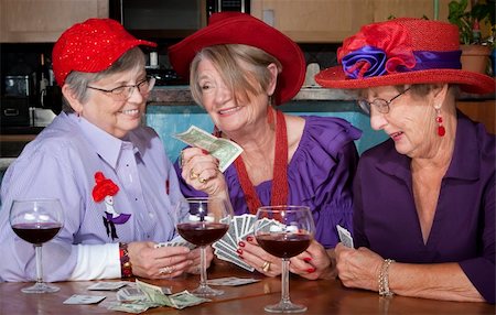 simsearch:400-04744719,k - Ladies wearing red hats playing a hand of cards Stock Photo - Budget Royalty-Free & Subscription, Code: 400-04593728