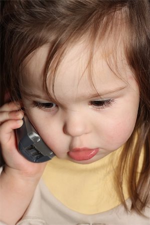 Small girl speaking over the phone Stock Photo - Budget Royalty-Free & Subscription, Code: 400-04604093