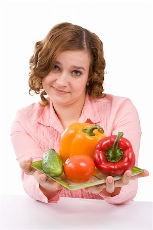 Woman wants to eat fresh vegetables. Housewife is holding the plate with pepper, tomato, cucumber. Pretty girl with fresh vegetables. Isolated over white background. Stock Photo - Budget Royalty-Free & Subscription, Code: 400-04604515