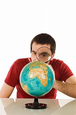 Man looking at globe through a magnifying glass - isolated Stock Photo - Budget Royalty-Free & Subscription, Code: 400-04605834