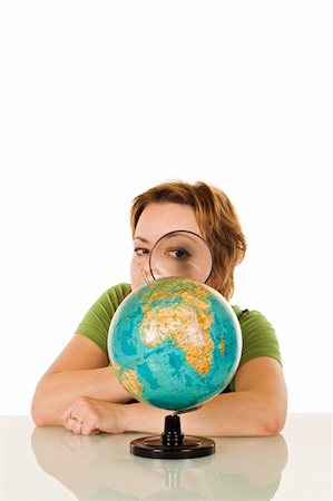 Beautiful woman looking at globe through a magnifying glass - isolated Stock Photo - Budget Royalty-Free & Subscription, Code: 400-04605833